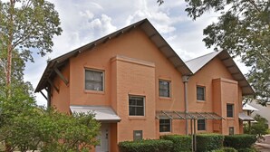 A two-story building with a brick facade, multiple windows, and a covered entrance.