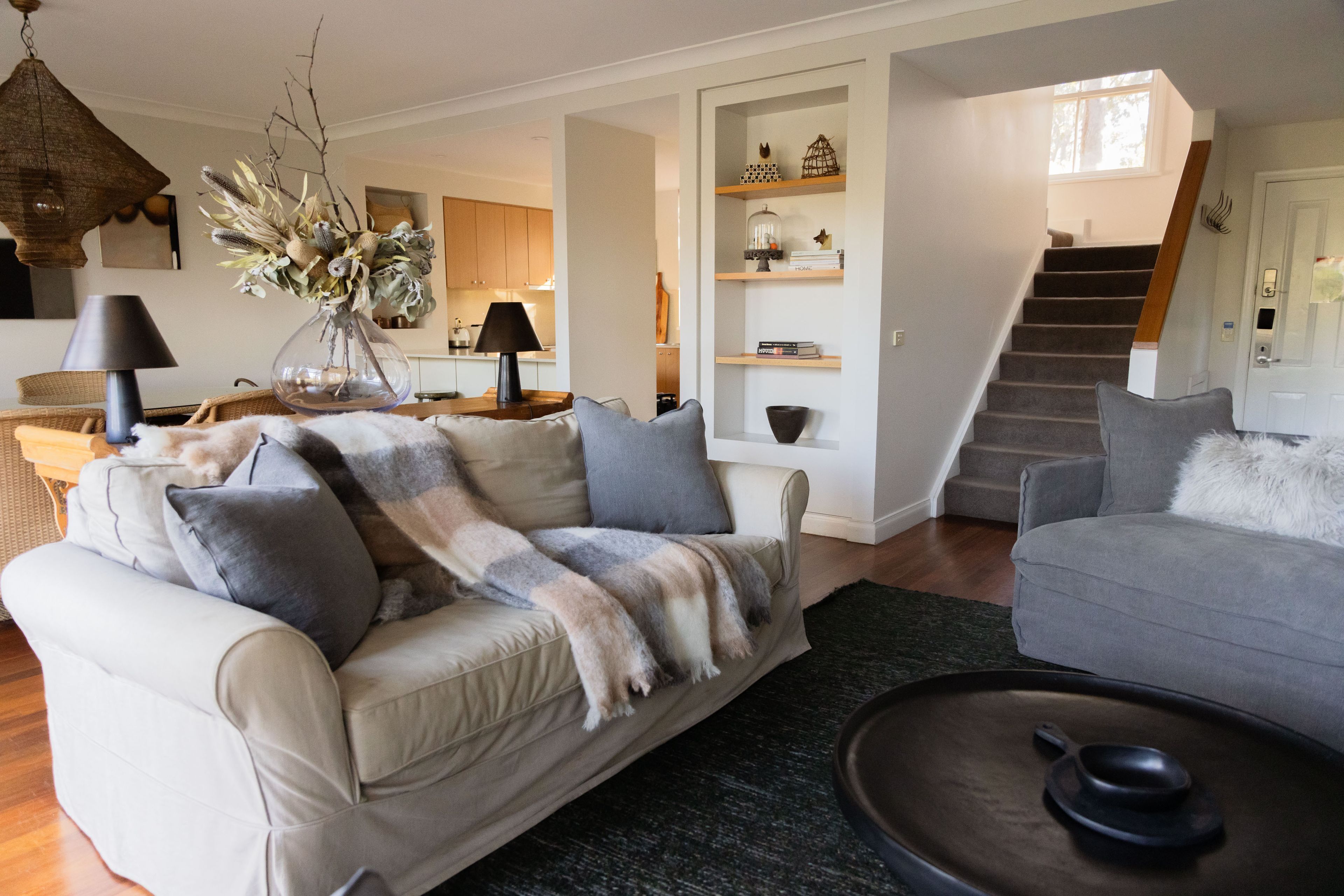 A living room with a sofa, a coffee table, a lamp, and a bookshelf.