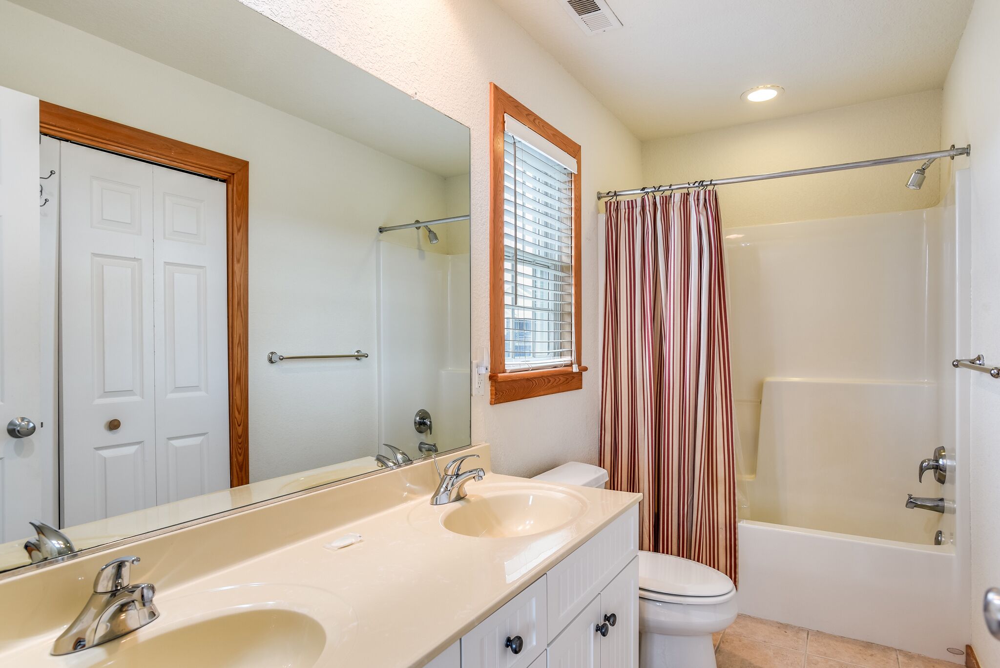 Une salle de bain avec deux lavabos, des toilettes, une baignoire et une douche.