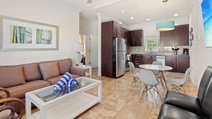 Un salon moderne avec un canapé, une table basse et un coin repas.