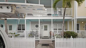 A two-story building with a white picket fence, a balcony, and a door with a window. - Another Three Hour Tour at The Truman Annex in Key West (Key West)