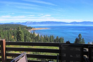A scenic view from a balcony overlooking a large body of water with mountains in the distance.