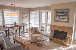 Cozy living room with a fireplace, comfortable seating, and dining area, perfect for relaxation and socializing.