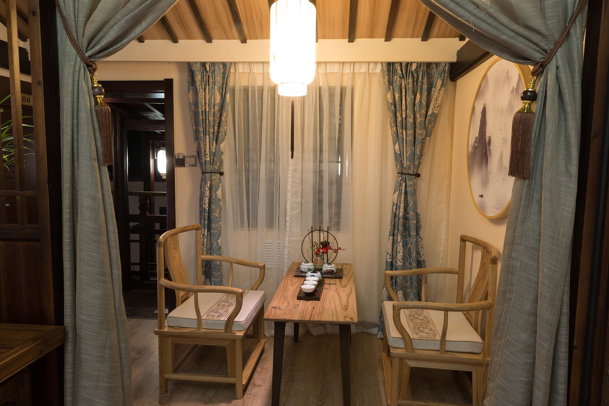 A cozy dining area with a wooden table and chairs, a hanging light fixture, and a wall-mounted decorative piece.