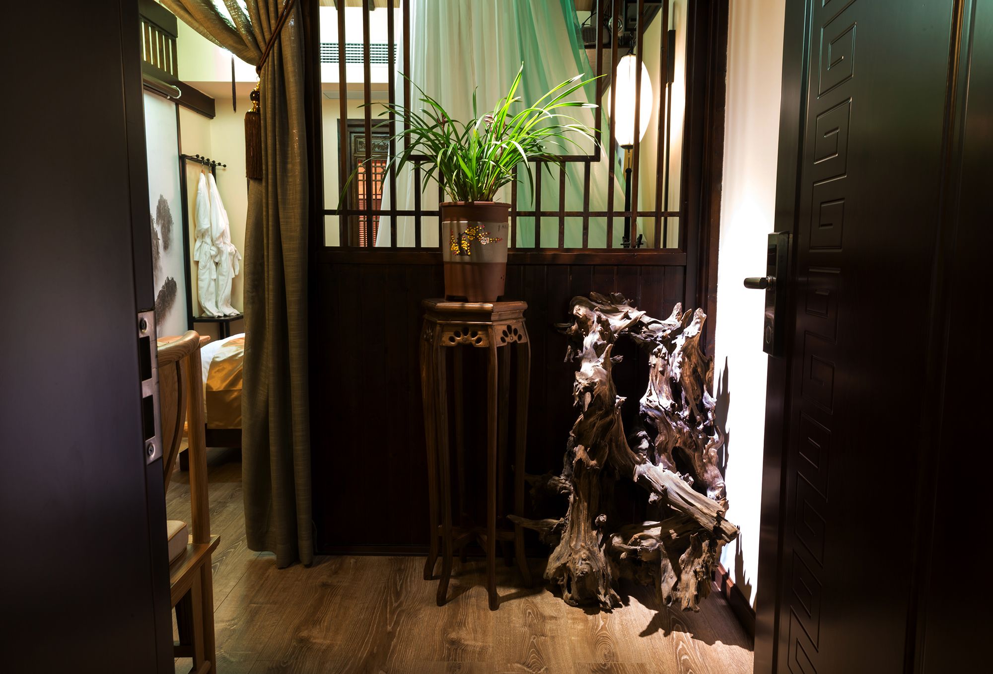 A wooden floor, a potted plant, a wooden sculpture, and a door.