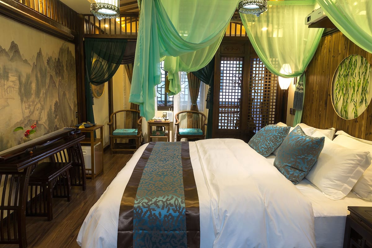 Una habitación tradicional con cama, sillas y escritorio.