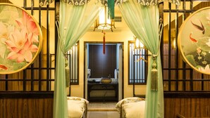 Une chambre traditionnelle avec un lit, une petite table et une fenêtre donnant sur l’extérieur.