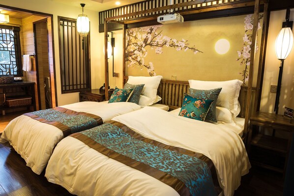 A traditional-style bedroom with two beds, wooden headboard, and a decorative wall with floral patterns.