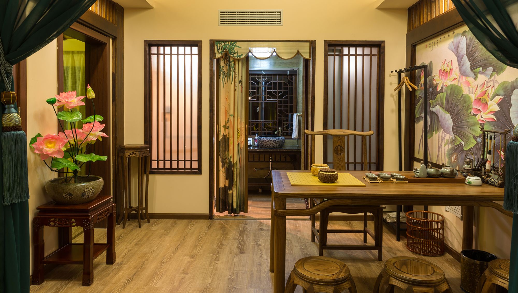 Una habitación tradicional japonesa con suelo de tatami, una mesa baja con utensilios para la ceremonia del té y un gran cuadro de flores de loto.