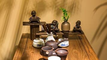 A wooden table with various ceramic tea sets and figurines.