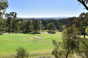 A golf course with a clear view of the fairway, sand bunkers, and surrounding trees. - Tranquility 3br Villa within Cypress Lakes Resort (Pokolbin)