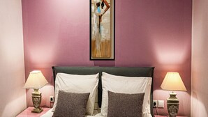 Ein Hotelzimmer mit einem Bett, zwei Nachttischen und einem Bild an der Wand.