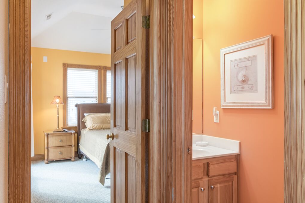 A bedroom with a bed, nightstand, and dresser.