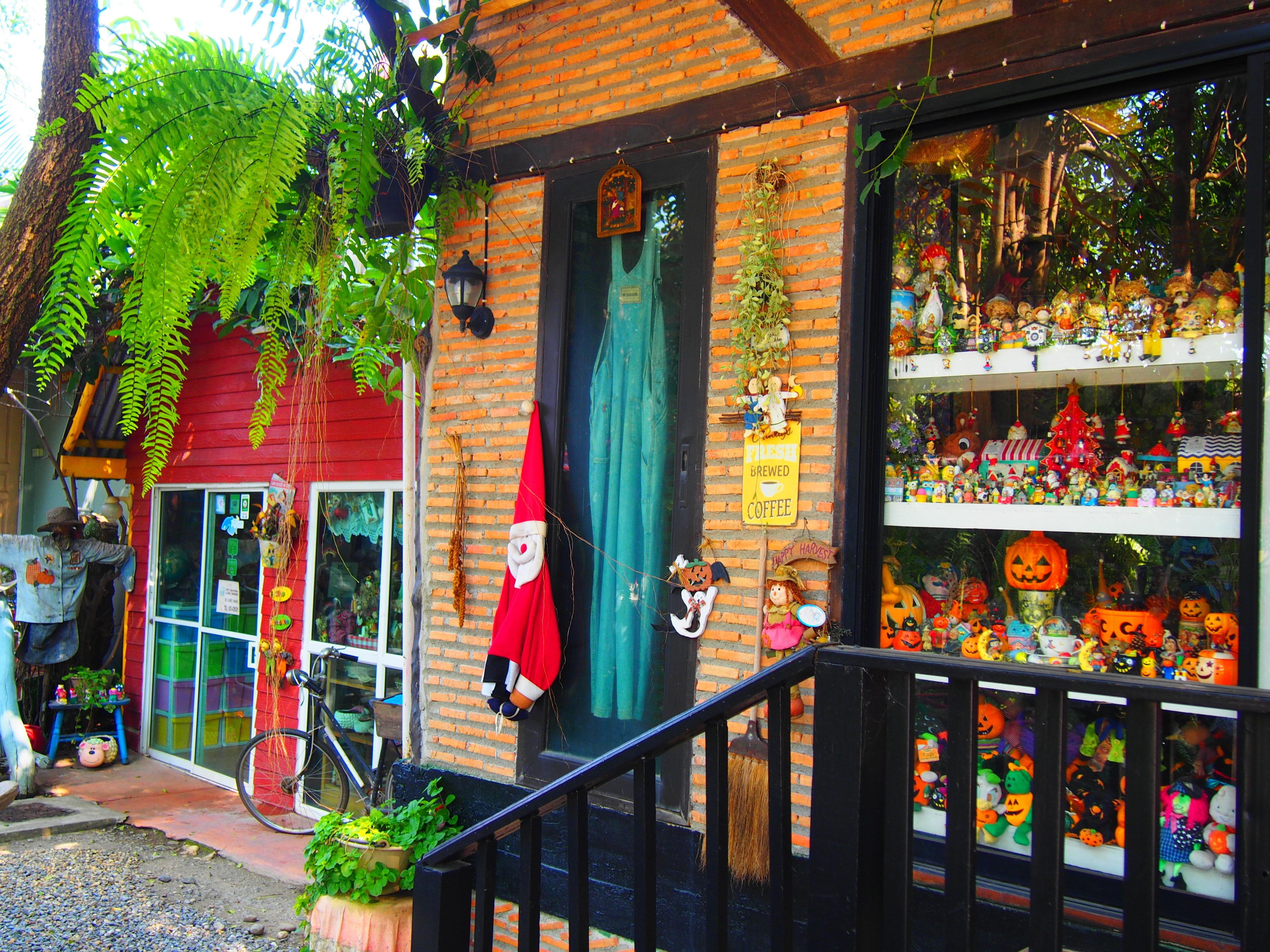 Een gevel van baksteen, een groen luifel en diverse Halloween-decoraties.
