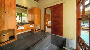 A bathroom with wooden cabinets, a stone sink, and a view of a pool. - Manca Villa Canggu by Ini Vie Hospitality (Canggu)