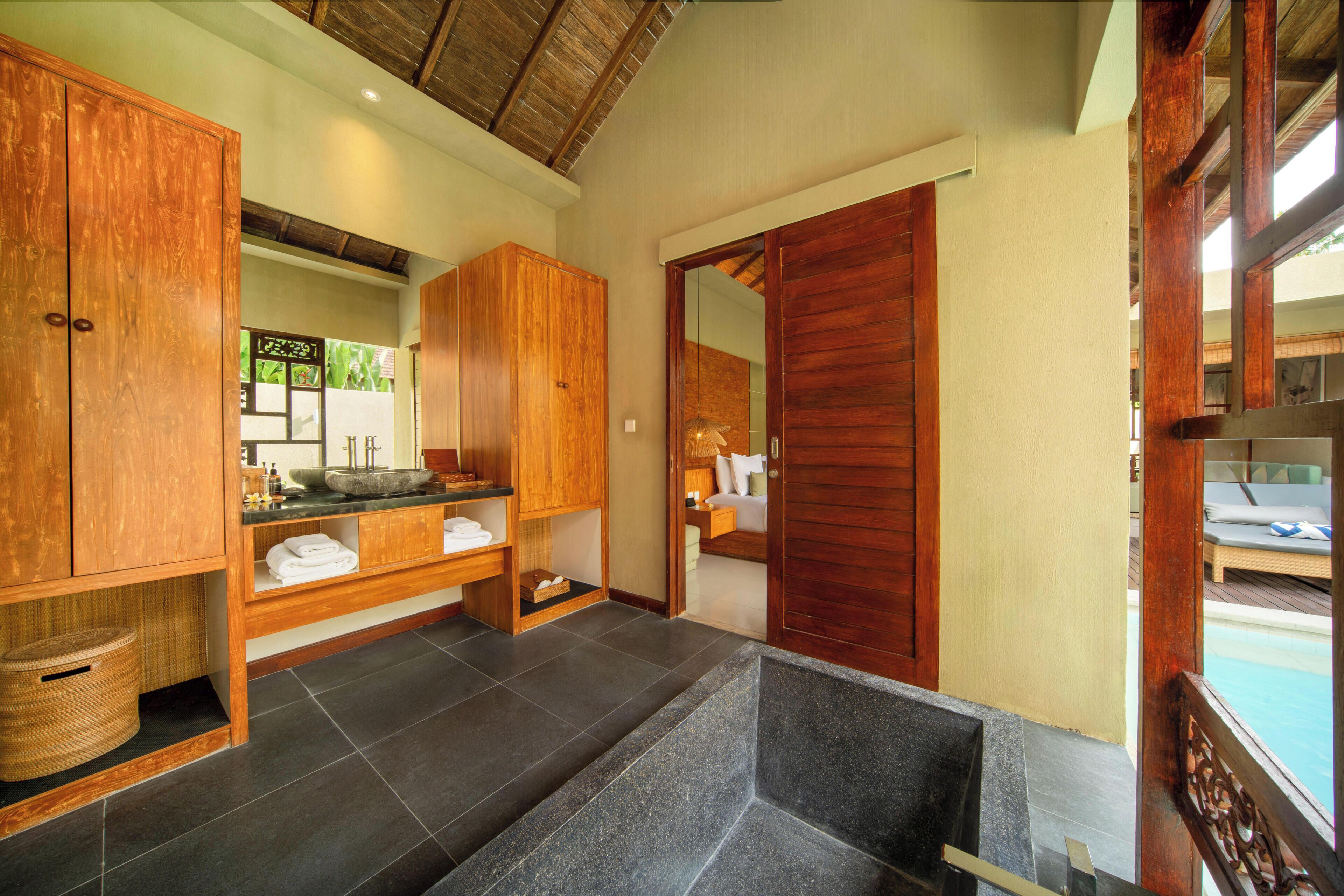 A bathroom with wooden cabinets, a sink, and a mirror.