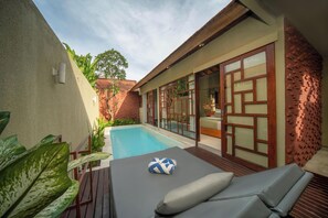 A poolside area with a lounge chair, a small pool, and a brick wall. - Manca Villa Canggu by Ini Vie Hospitality (Canggu)