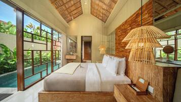 A spacious bedroom with a large bed, a wooden headboard, a bedside table, and a view of a swimming pool.