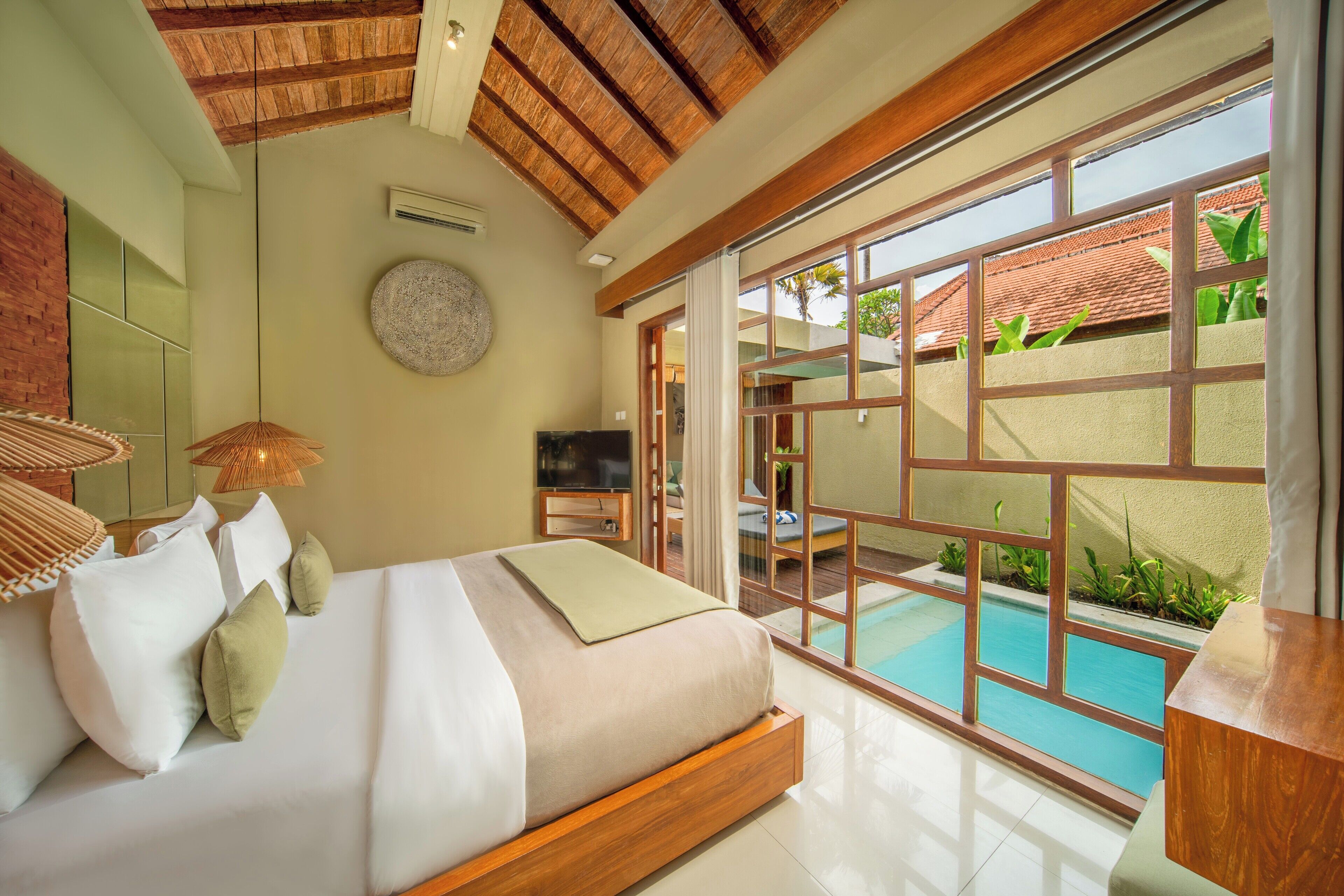 Une chambre avec un grand lit, une télévision et une vue sur une piscine.
