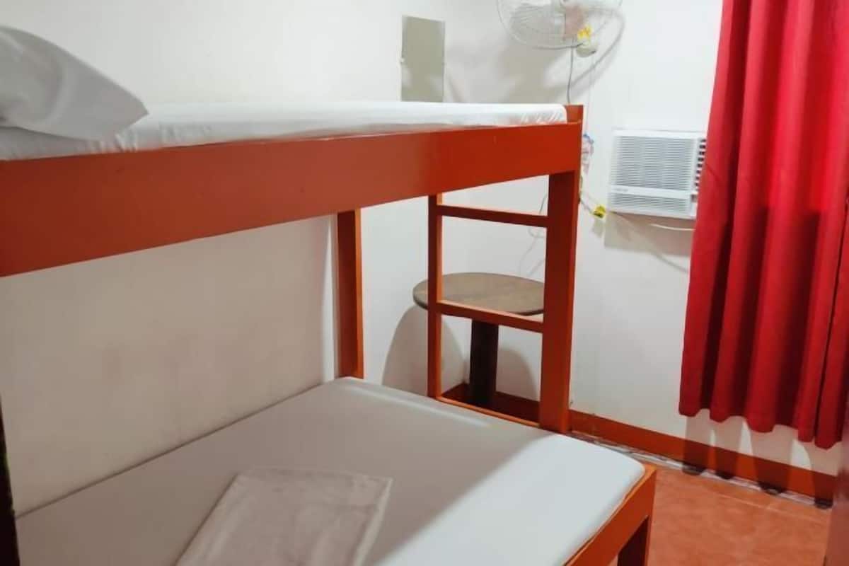 A bunk bed with a white mattress and a wooden frame.