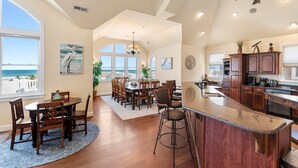 Ett rymligt kök med träskåp, en stor köksö och utsikt över havet.