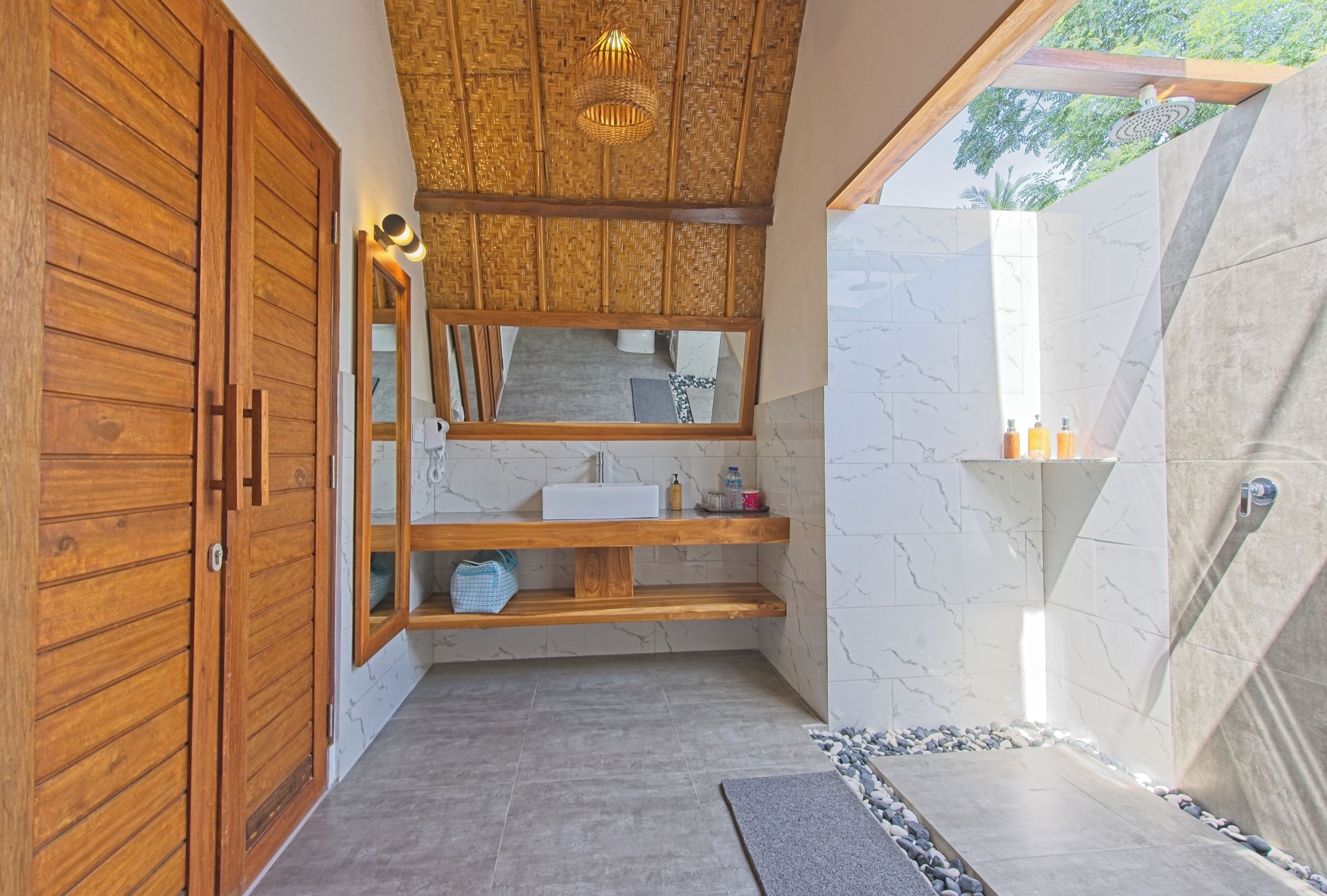 Une salle de bain moderne avec un meuble-lavabo en bois, un miroir, un évier et un espace douche.