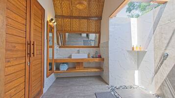 Une salle de bain moderne avec un meuble-lavabo en bois, un miroir, un évier et un espace douche.