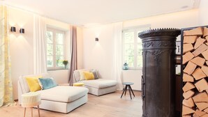 Un salon moderne avec un canapé, un pouf et une haute colonne décorative.
