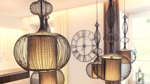 Un intérieur moderne agrémenté de luminaires suspendus et d’une grande horloge murale.