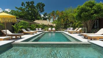 Alberca al aire libre y camastros