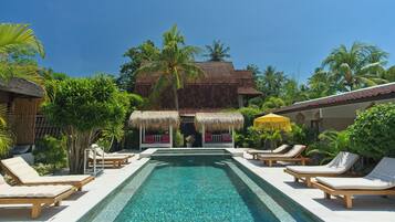 Alberca al aire libre y camastros