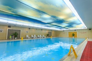 An indoor swimming pool with clear water, a ceiling with a sky-like design, and a red safety mat along the pool edge. - Changsha Xiaoxiang Huatian Hotel (Changsha)