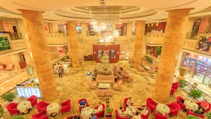 A spacious lobby with red seating, a central floral arrangement, and a chandelier. - Changsha Xiaoxiang Huatian Hotel (Changsha)