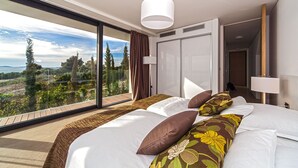 Habitació d'hotel moderna amb un llit gran, vista a l'exterior i un armari amb portes corredisses.