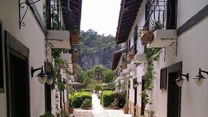 A narrow stone-paved alleyway flanked by buildings with balconies, potted plants, and outdoor lighting fixtures. - Aydos Club (Ortaca)
