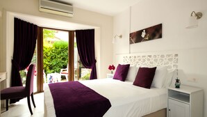 A hotel room with a bed, a chair, a nightstand, and a window with curtains. - Aydos Club (Ortaca)
