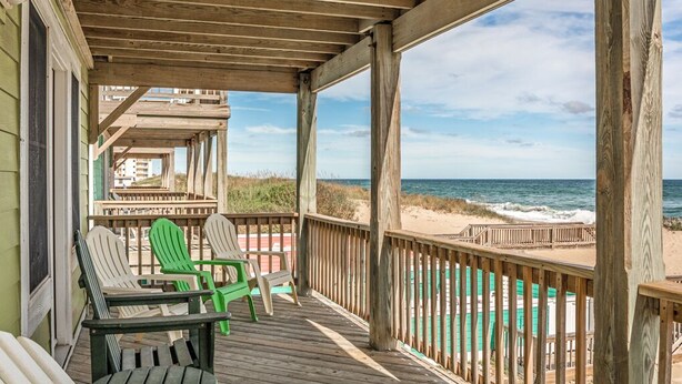 A wooden deck with chairs overlooking a beach. - Ocean's Edge: Oceanfront, Pool, Spa, Dogs OK (Nags Head)