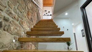 Una moderna scala con gradini in legno e una parete in pietra su un lato.