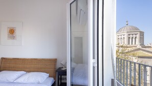 Une chambre d’hôtel avec un lit, un bureau et une vue sur un bâtiment doté d’un dôme et de croix.