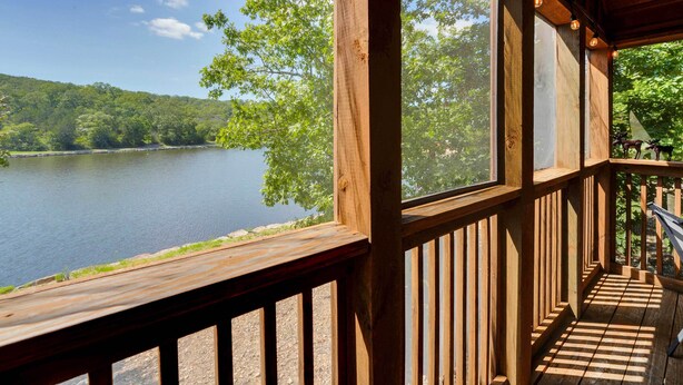 A wooden deck with a view of a lake and forest.