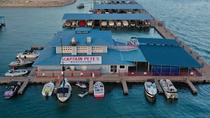 Uma marina com barcos atracados e um armazém de barcos chamado 'Captain Pete's Boathouse'.