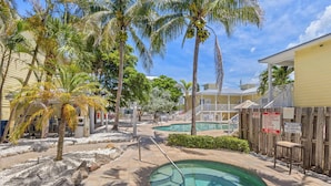 A pool area with palm trees, a small pool, and a wooden fence. - The Beach Club at Siesta Key #106A Resort by RVA (Sarasota)