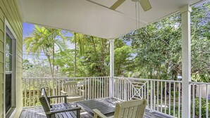 A covered outdoor area with a wooden deck, white railings, and a ceiling fan. - The Beach Club at Siesta Key #106A Resort by RVA (Sarasota)