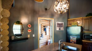 A modern kitchen with a granite countertop, stainless steel sink, and a black refrigerator. - Cozy Log Home -King bed, full kitchen, bathroom with clawfoot tub, outdoor area  (Talkeetna)