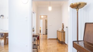 A spacious room with a wooden floor, a piano, and a lamp.