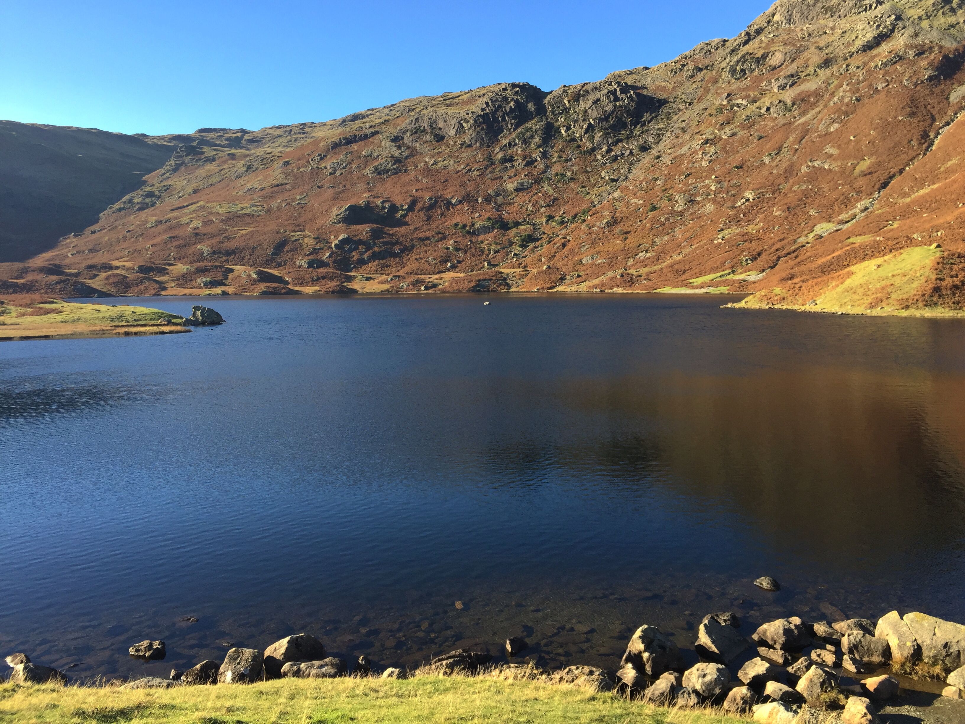 Un lac paisible, entouré de collines rocheuses.