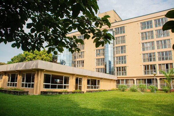 A modern building with a flat roof, large windows, and a grassy courtyard.