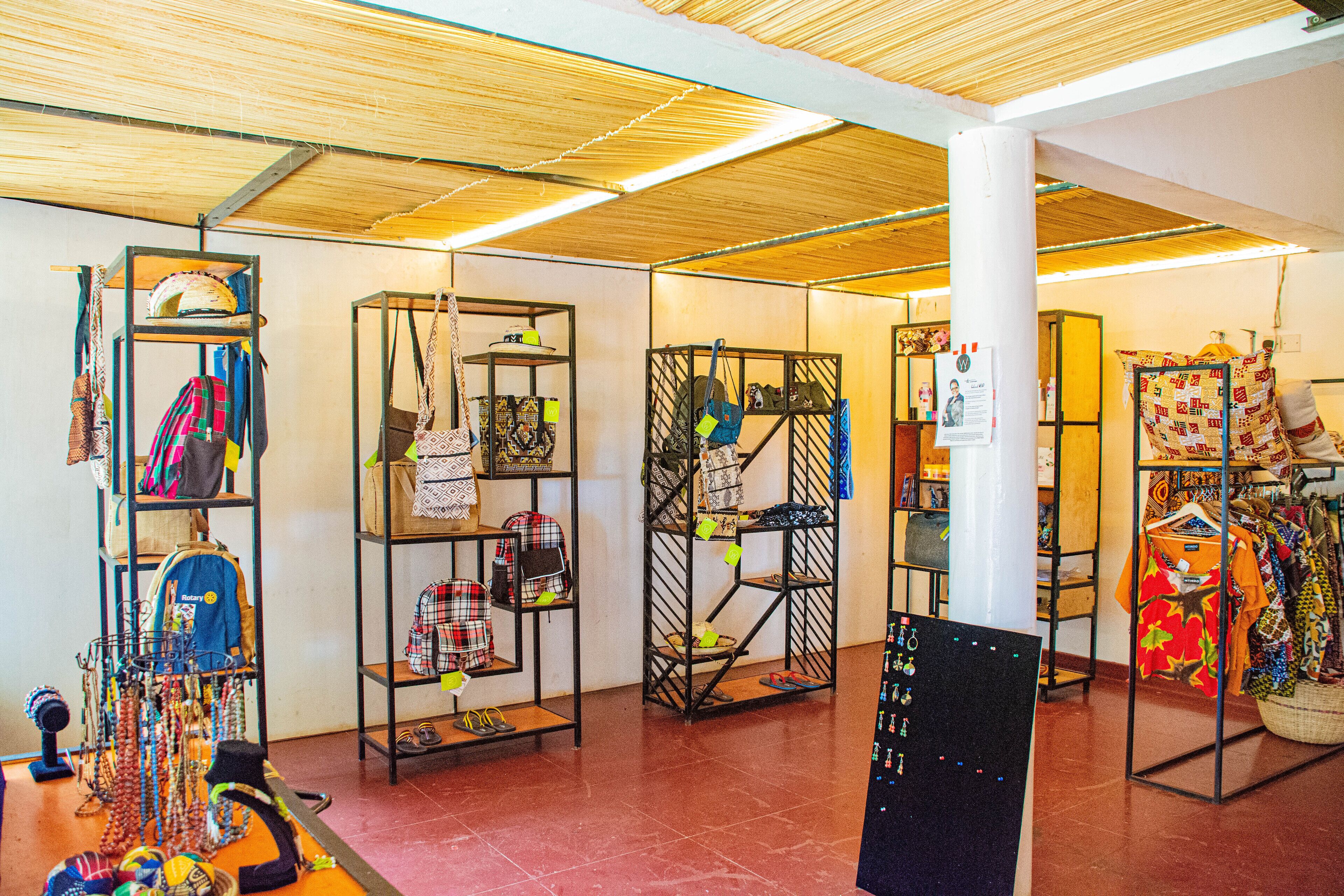 A room with shelves displaying bags and clothing.