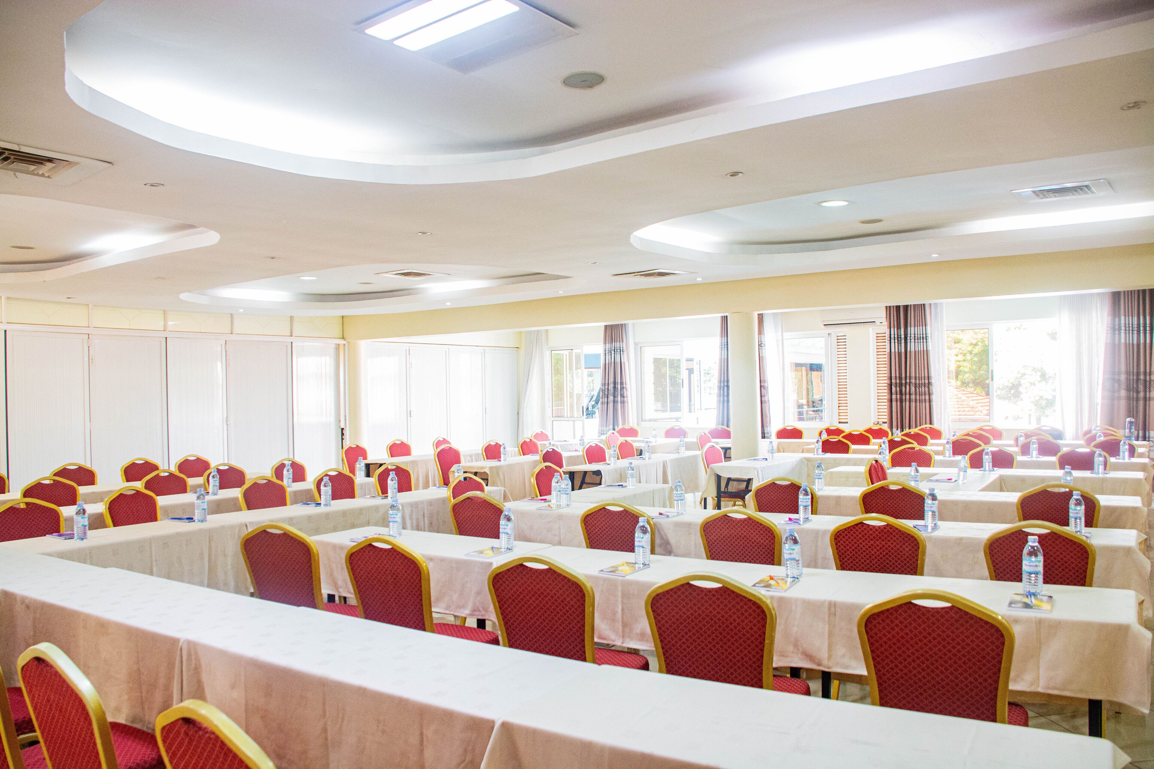 A conference room with multiple tables and chairs, equipped with water bottles and nameplates.