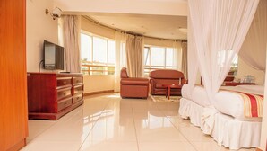Una habitación de hotel con una cama, un televisor, un escritorio y una silla.